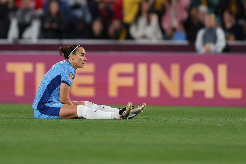 England's Lucy Bronze sits on the grass looking sad during the Women's World Cup final.