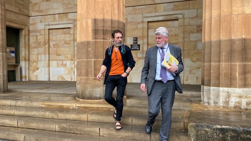 Two men walking down the steps of a court building
