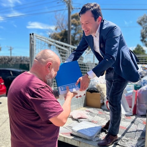 A photo of Adam receiving packages from a truck unloaded by Hume mayor.