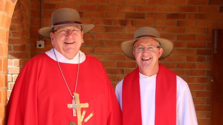 Two Catholic priests stand beside each other