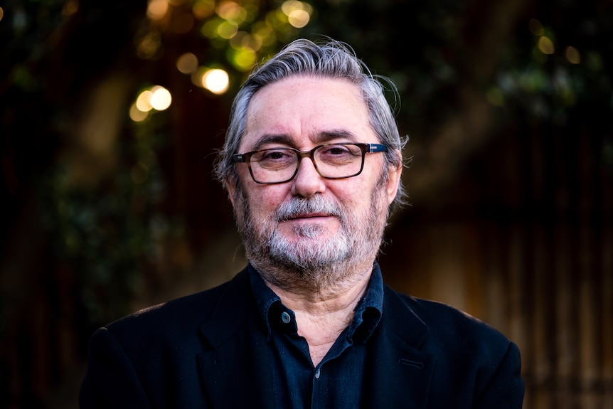 A close-up portrait of Greg Lockhart, who looks into the camera with a blank expression.