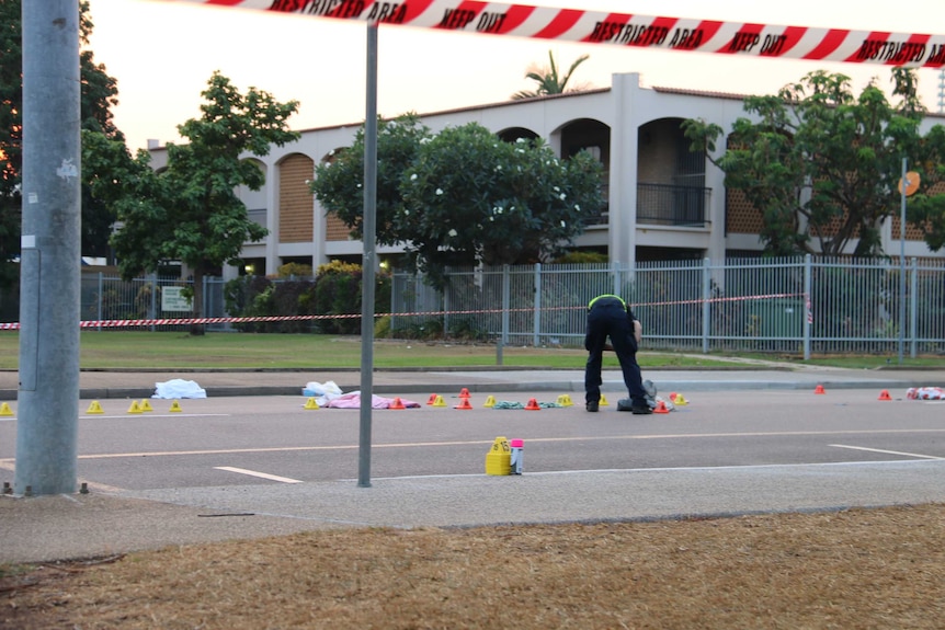 An officer examines the scene where a woman was killed