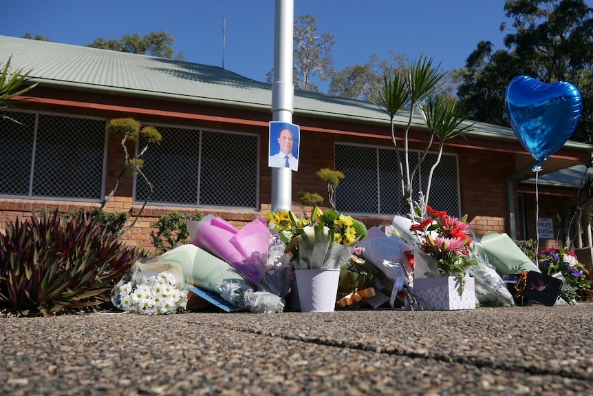 Floral tributes around a pole at the police station.