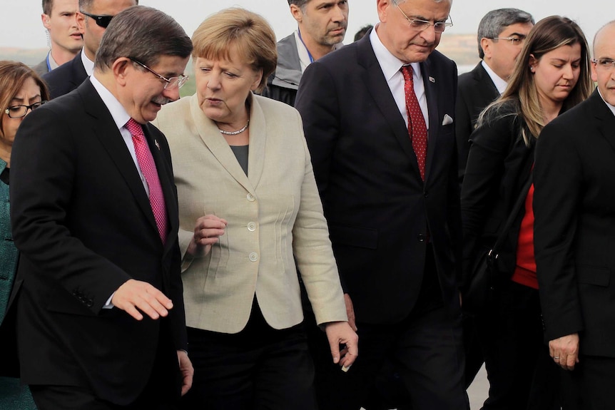 Turkish Prime Minister Ahmet Davutoglu welcomes German Chancellor Angela Merkel.