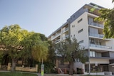 Two small houses next to a six-storey block, East Perth