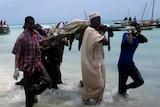 Rescuers carry the bodies of victims from a ferry tragedy near Zanzibar Island at Nungwi Beach September 10, 2011