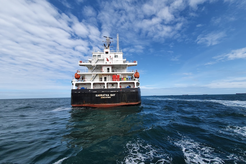 Stern view of a large cargo ship travelling through open water