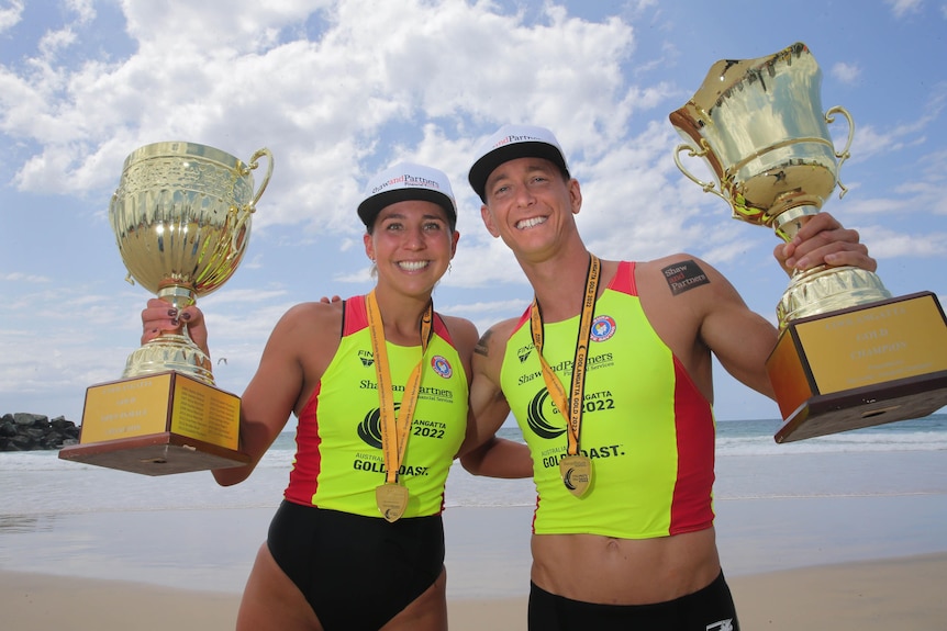 man and woman with trophies