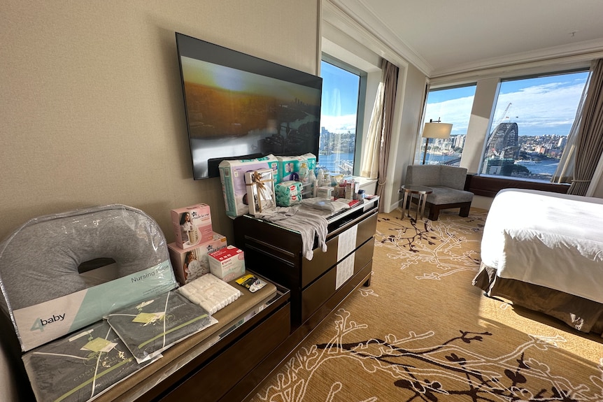 A hotel room with nappies and baby clothes prepared on the table