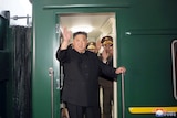 North Korean leader Kim Jong Un waves from a private train.