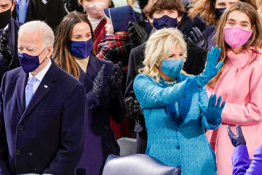 Joe Biden and Jill Biden surrounded by their grandchildren waving