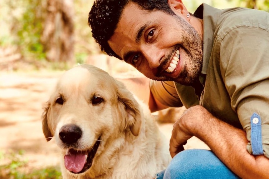 Patrick Abboud smiling at the camera with his dog