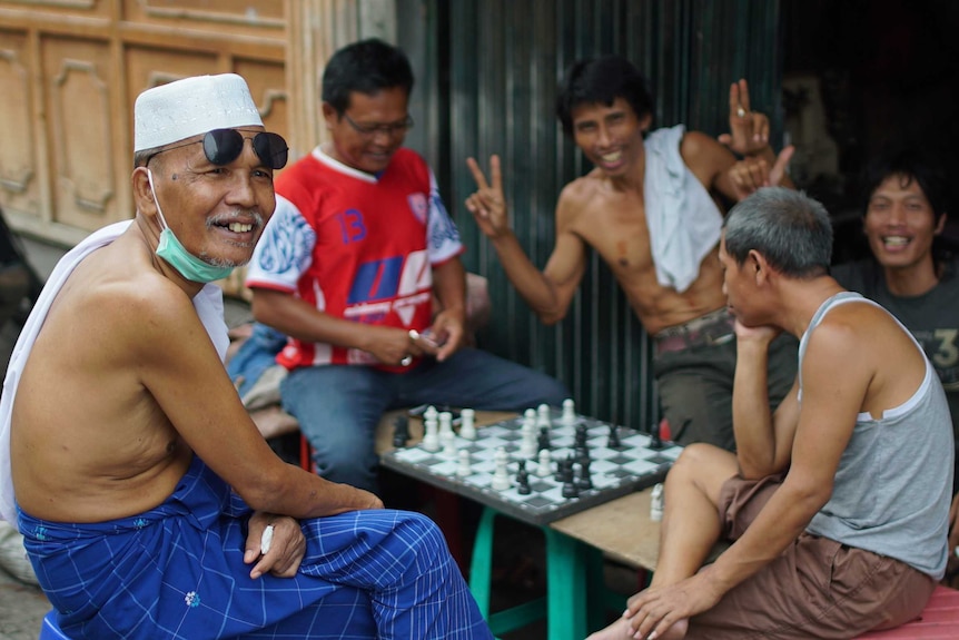 Men play chess in the Tambora slum in Jakarta