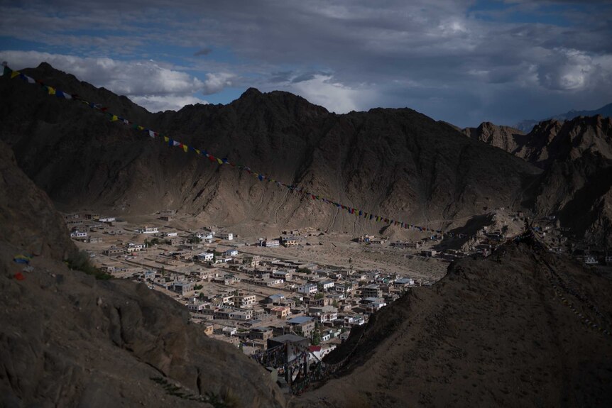 A shot taken from above shows Leh covered with prayer flags.