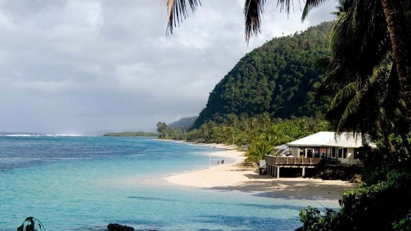 A beach with blue water and a resort