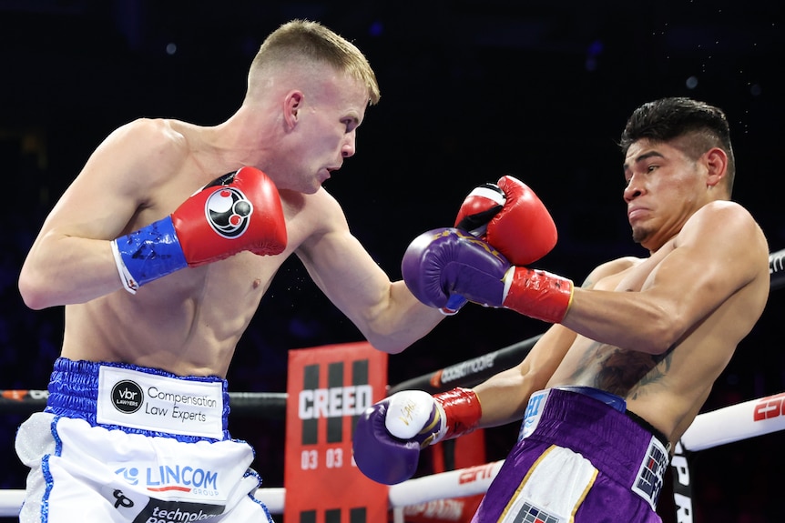 Liam Wilson leans over Emanuel Navarrete with a cocked fist