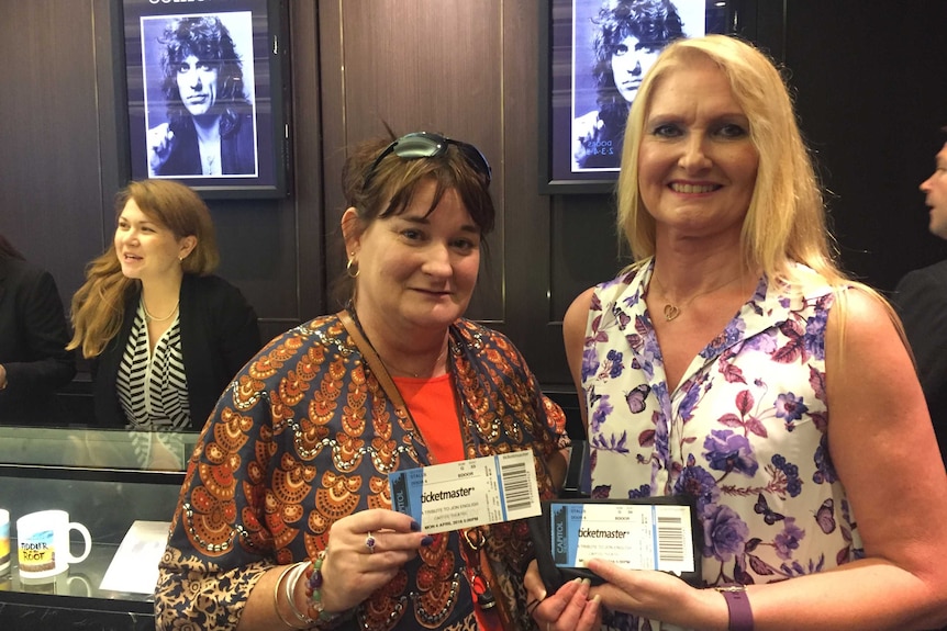 Cynthia Getchell-Rouse (left) and Lizzy McSherry hold up their Jon English memorial tickets.