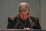 Cardinal George Pell looks down as he addresses the media at the Vatican.