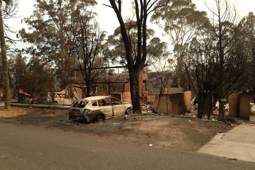 The burnt out remains of a car and house in Springwood.