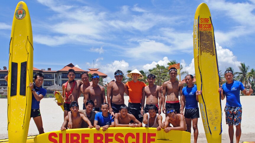 The trainee Vietnamese lifesavers pose with boards with Aussie lifeguard Katherine Waterhouse 27 January 2012