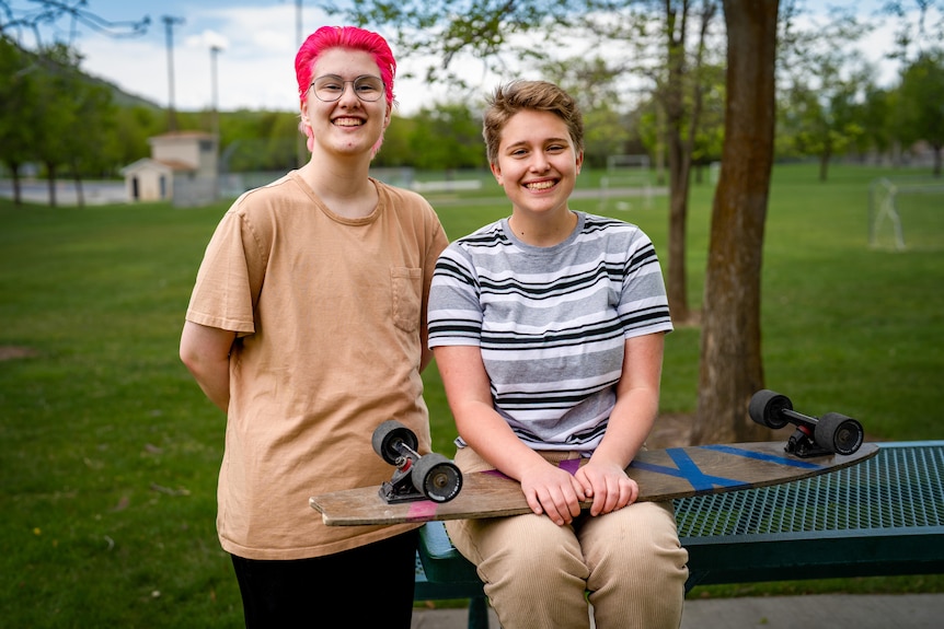 Two teenagers smiling together in a park 
