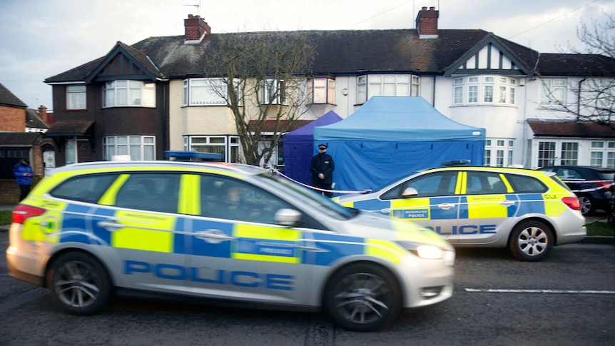 Police cars drive outside Mr Glushkov's home which has a forensics tent set up outside.