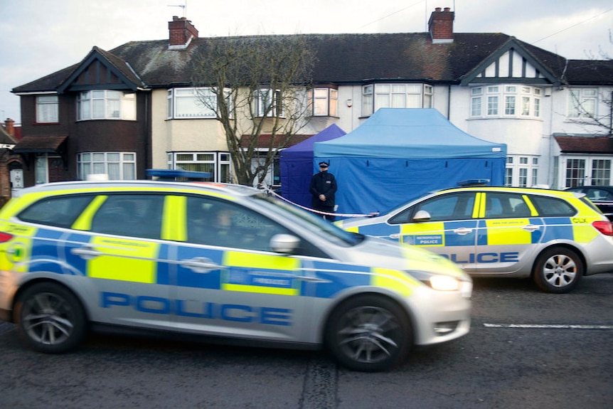 Police cars drive outside Mr Glushkov's home which has a forensics tent set up outside.