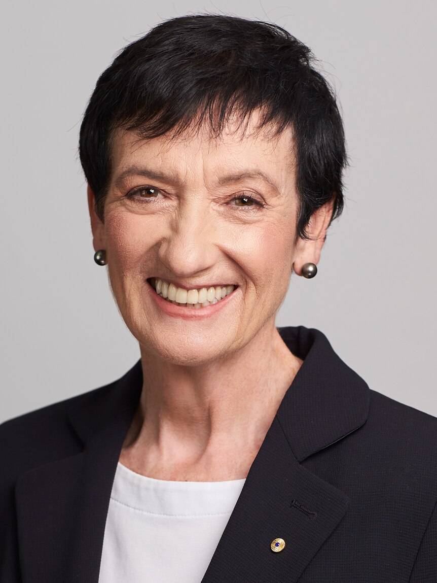 Portrait of a middle-aged woman with short brown hair and a blazer.