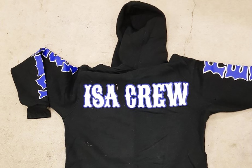 A black hooded jumper with Isa Crew written on the back