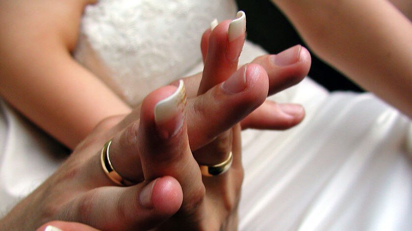 A generic close-up of a couple's hands on their wedding day