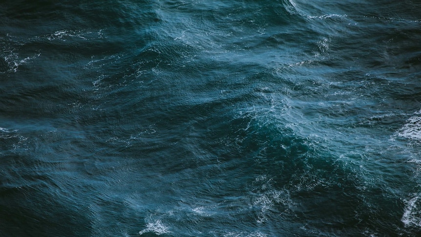 A close up photo of waves in the deep ocean