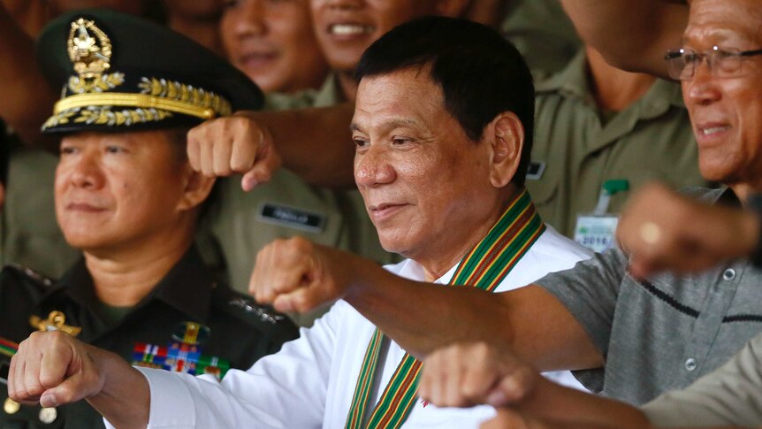 Rodrigo Duterte stands next to Defence chief Delfin Lorenzana and Army chief Eduardo Ano.