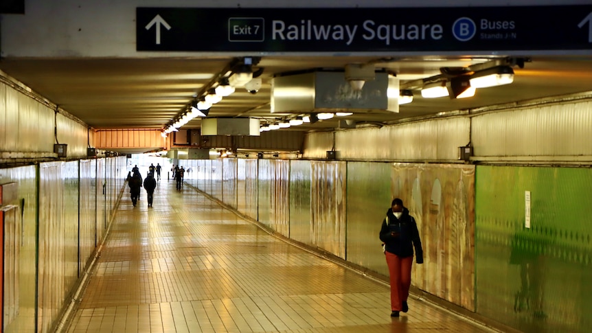 a woman walking through a tunnel