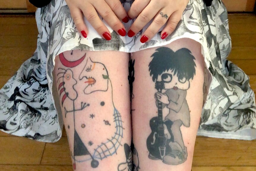 Tattoo of a cartoon male version of Betty Boop on a woman's leg.