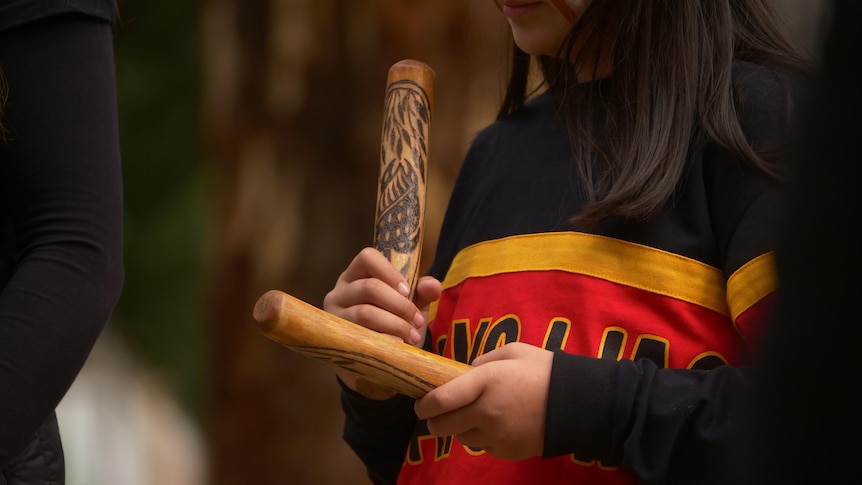 Someone clapping Aboriginal clapping sticks. 