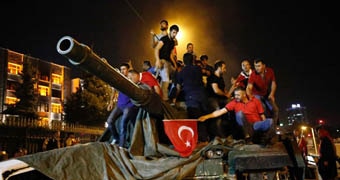 People stand on a Turkish army tank in Ankara.