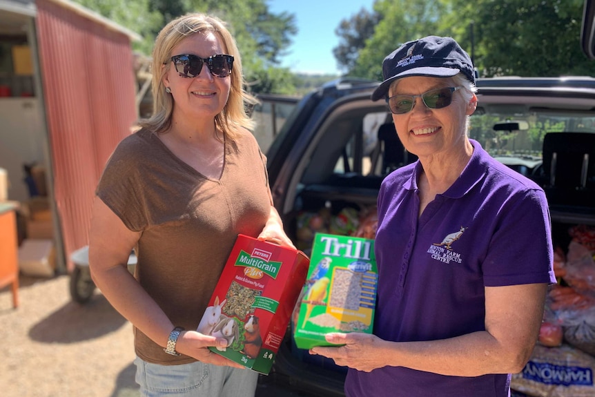 Tanya Veltman holding a box of multigrain next to Bev Langley holding a box of bird seeds