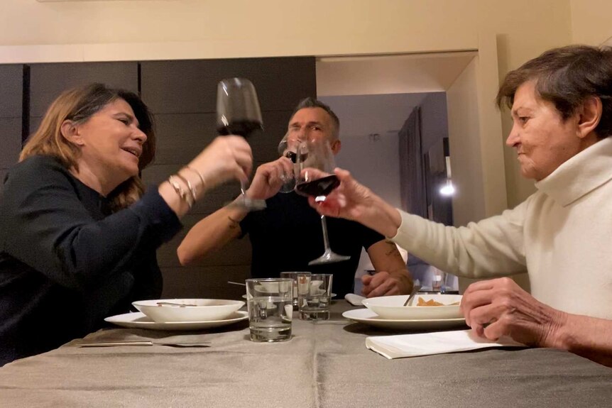 Emi, Maria and Ariel raise glasses over dinner.