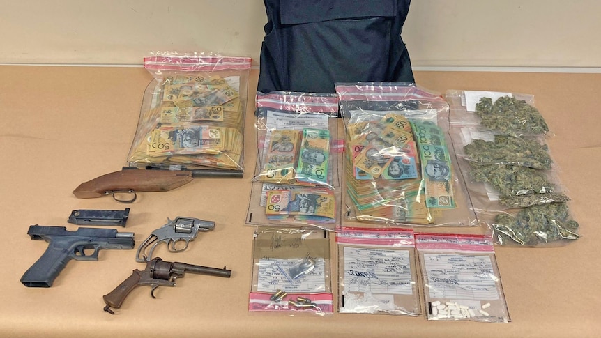 Zip-lock bags on a table containing Australian bank notes, firearms and illicit drugs.