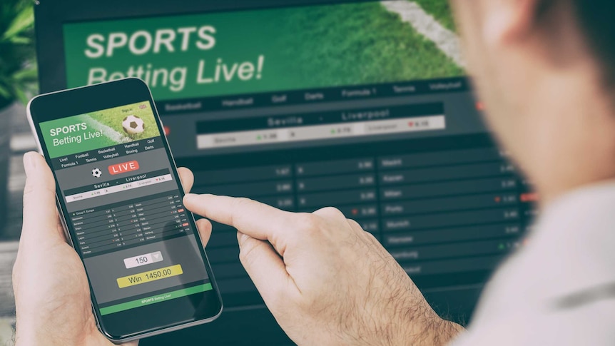 Man betting on smartphone on Sports Betting Live.