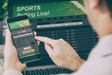 Man betting on smartphone on Sports Betting Live.