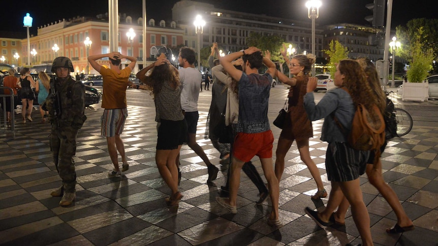 Revellers leave the scene with their hands on their heads