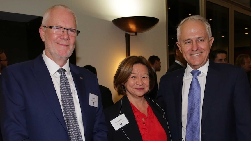 Justin Milne, Michelle Guthrie and Malcolm Turnbull stand together for a photograph at an evening function.