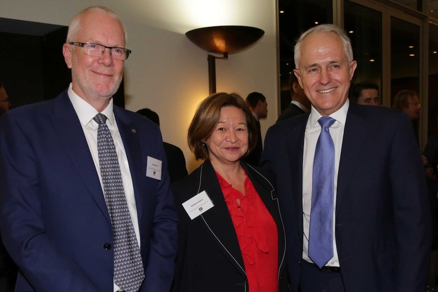 Justin Milne, Michelle Guthrie and Malcolm Turnbull stand together for a photograph at an evening function.