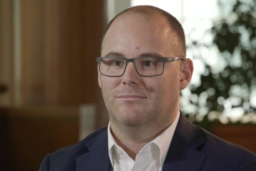 Gerard Benedet wears a white shirt and suit jacket