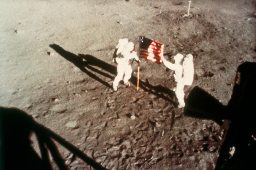 Neil Armstrong and Buzz Aldrin unfurl the American flag on the moon in June 1969