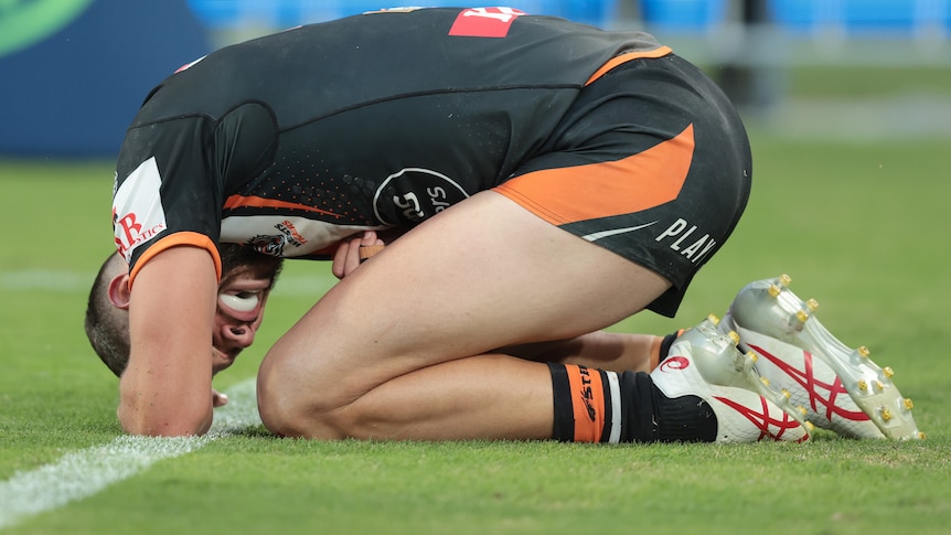 A rugby league player slumps on the ground after an injury