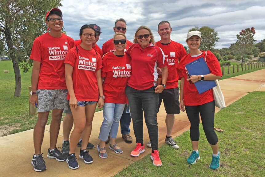 Labor volunteers in red shirts standing in a park