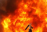 An Iranian opposition supporter gestures next to a burning police motorcycle
