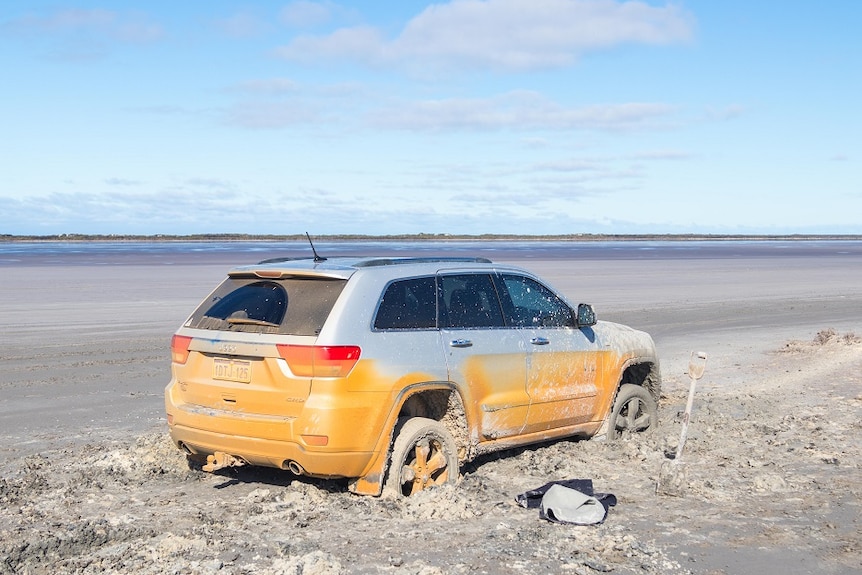 The silver car, bogged